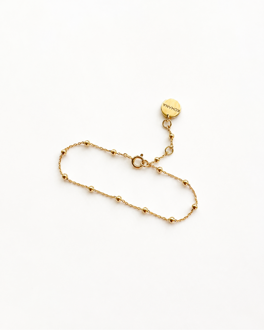 A delicate gold chain bracelet with small bead accents 