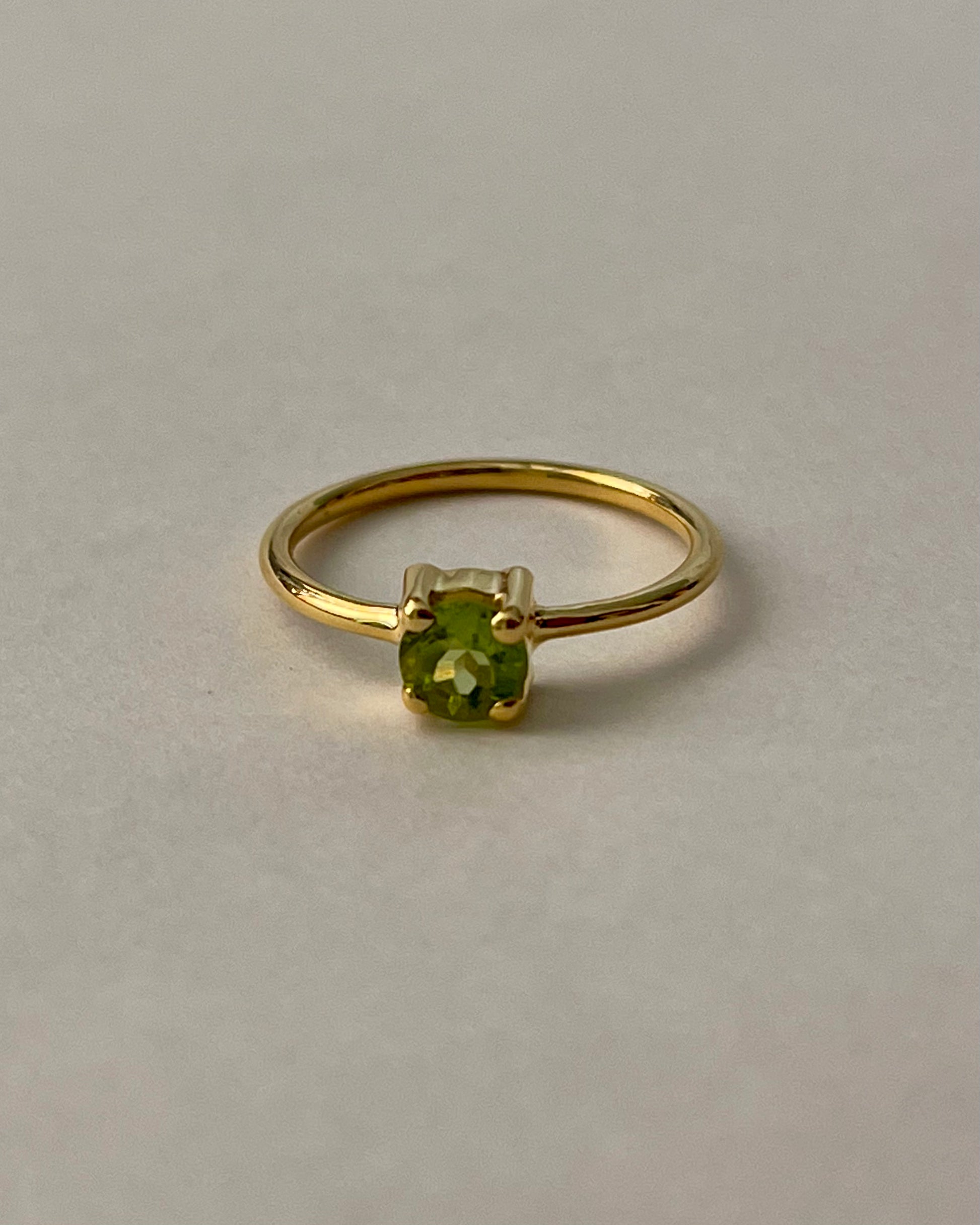Gold ring with a green gemstone, slow fashion jewelry brand  