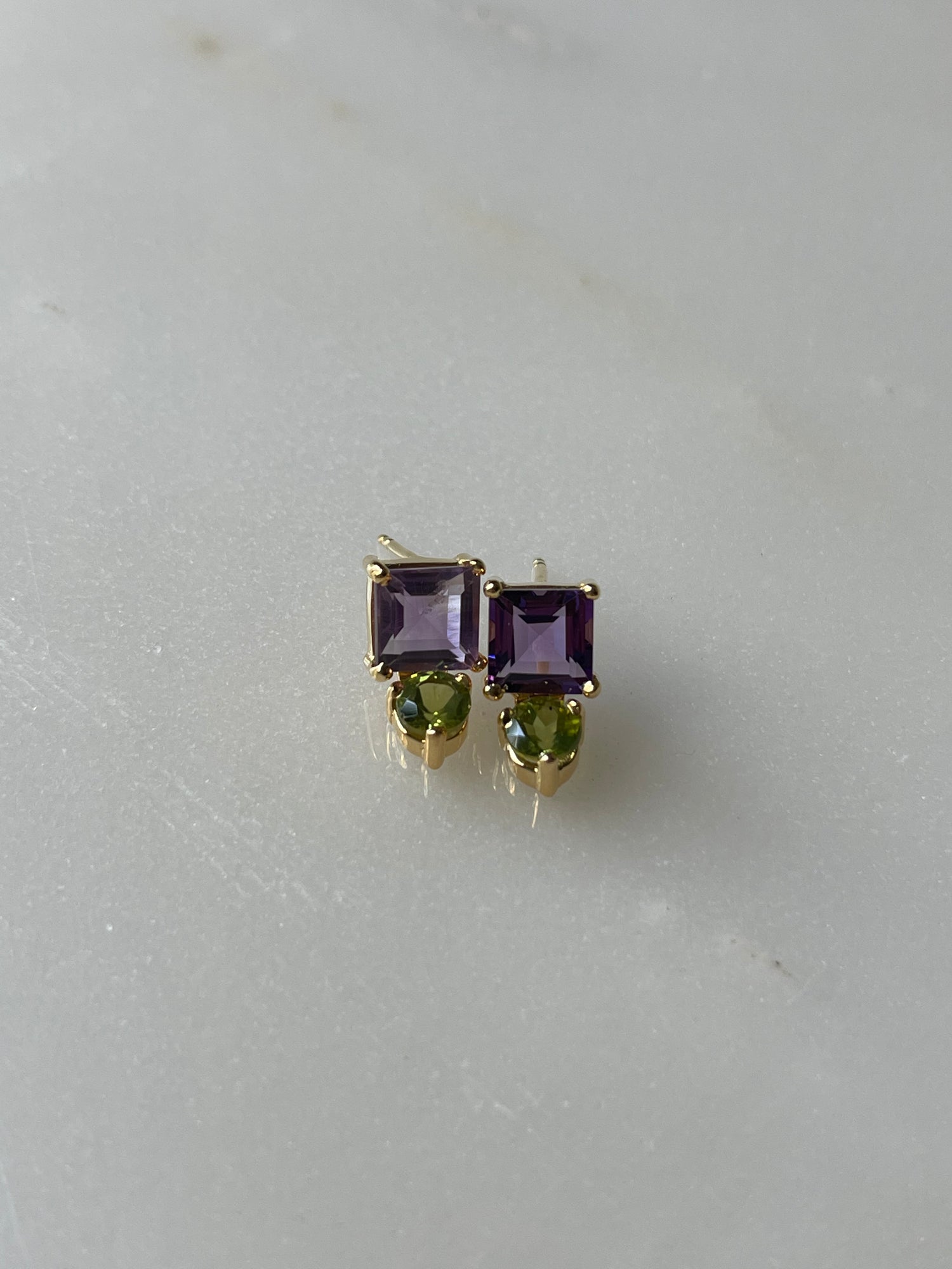 Pair of gold earrings with purple and green gemstones